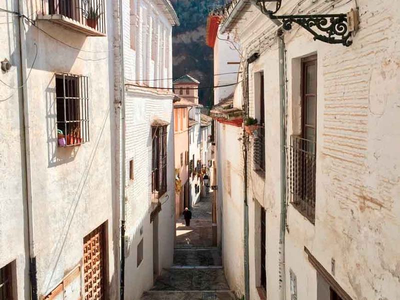 Ruelle blanchie à la chaux dans l'Albaicín avec l'Alhambra en arrière-plan